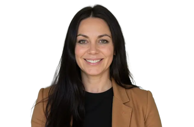 A woman with long dark hair wearing a black blazer, standing confidently with a neutral expression.